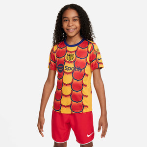 NIKE JR BARCELONA 23-24 PRE-MATCH SS TOP UNIVERSITY GOLD/MIDNIGHT NAV